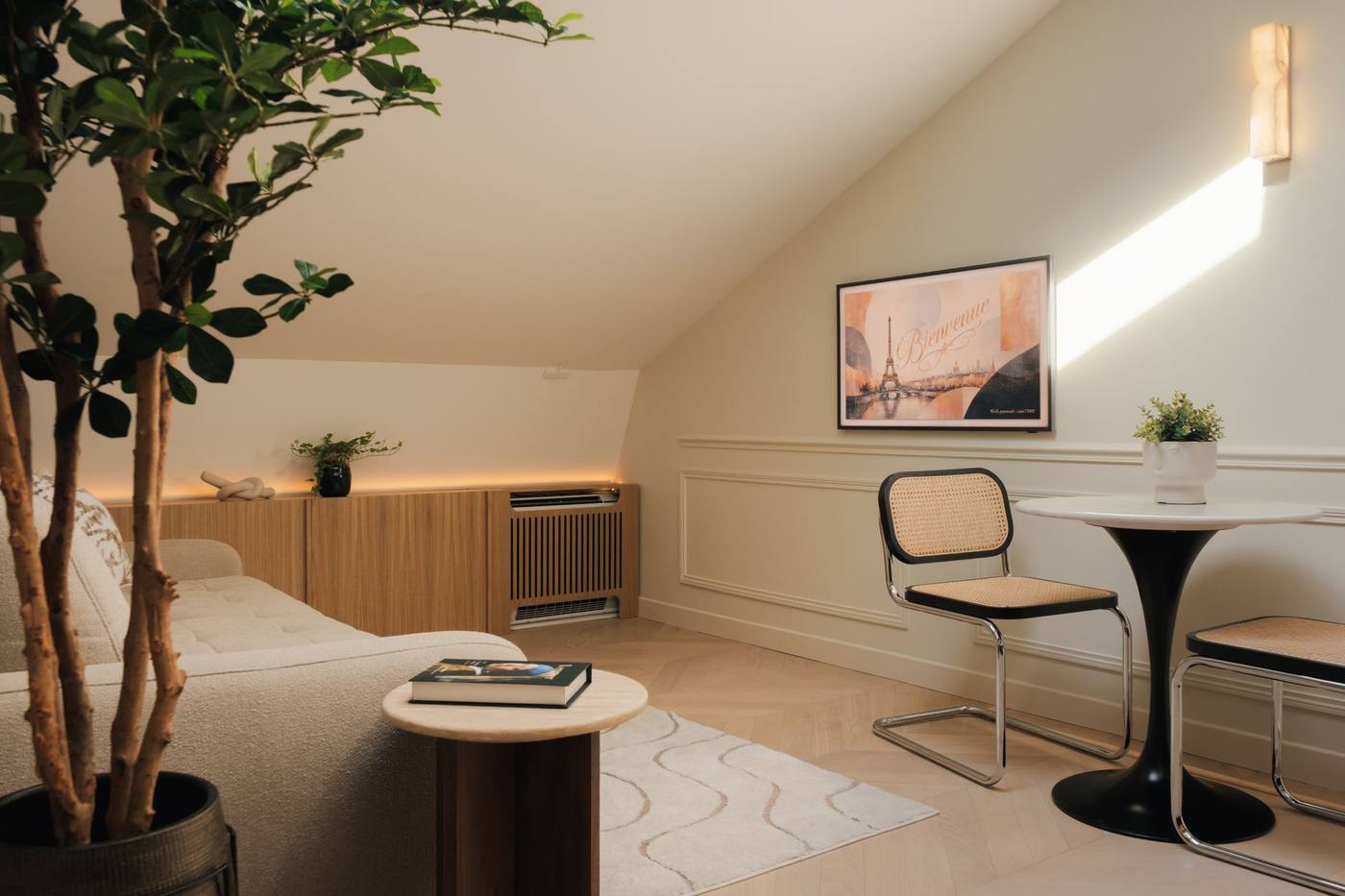 Séjour sous les combles, ficus et coin repas près du velux